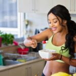 A woman eating fruit from a bowl