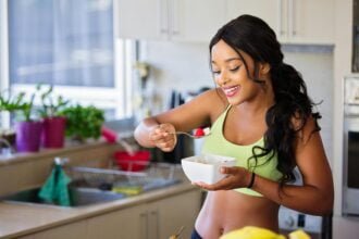 A woman eating fruit from a bowl